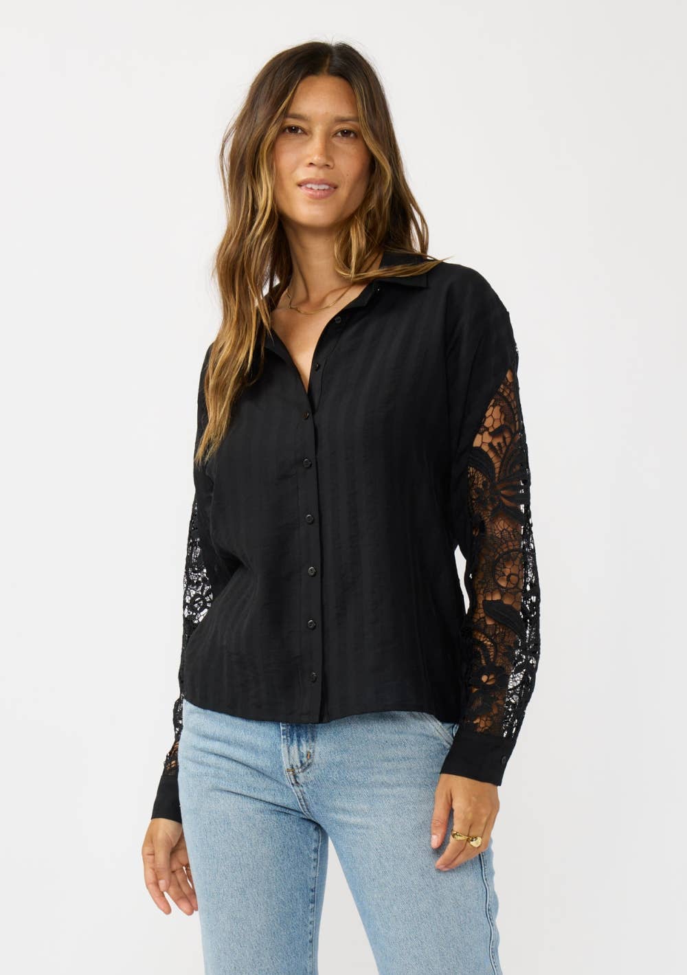 Woman wearing a black shirt with lace sleeves on a white background