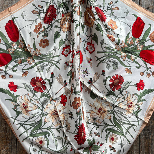 Floral patterned fabric with red and green colors on a wooden surface