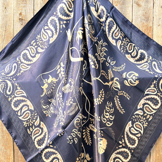 A blue and cream paisley wild rag tied around the neck, displayed on a denim jacket.
