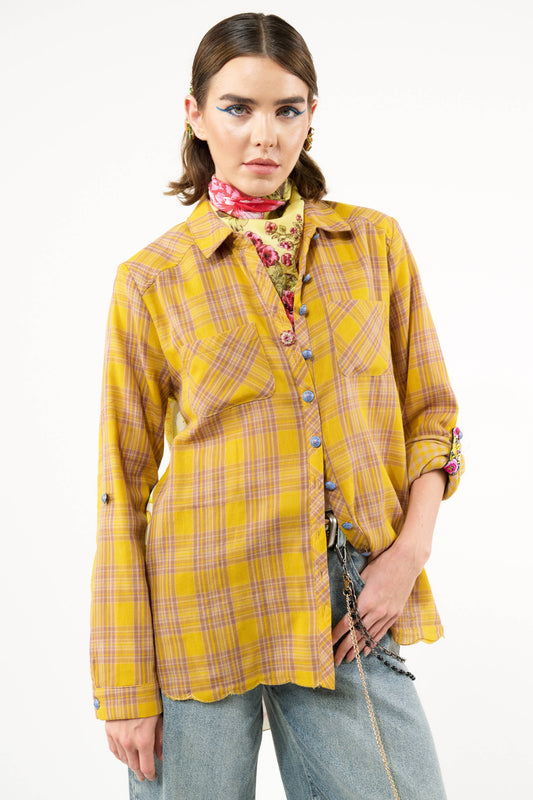 A person wearing a long sleeve button-up shirt with a plaid design on the sleeves and a floral/horse print on the back.