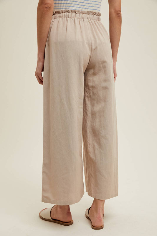 Beige wide-leg pants worn by a person on a plain background