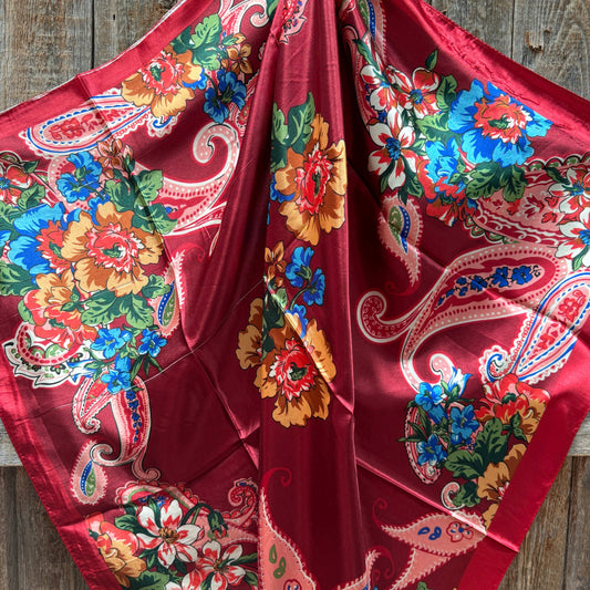 Red floral and paisley patterned fabric on a wooden surface