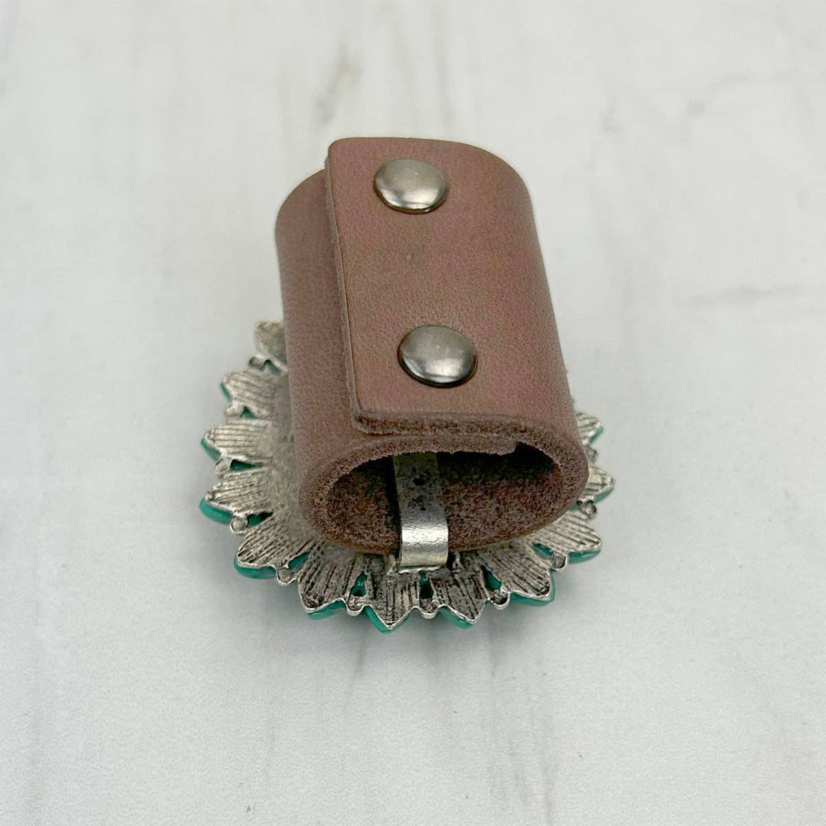 Brown leather strap with metal buckle on a white background