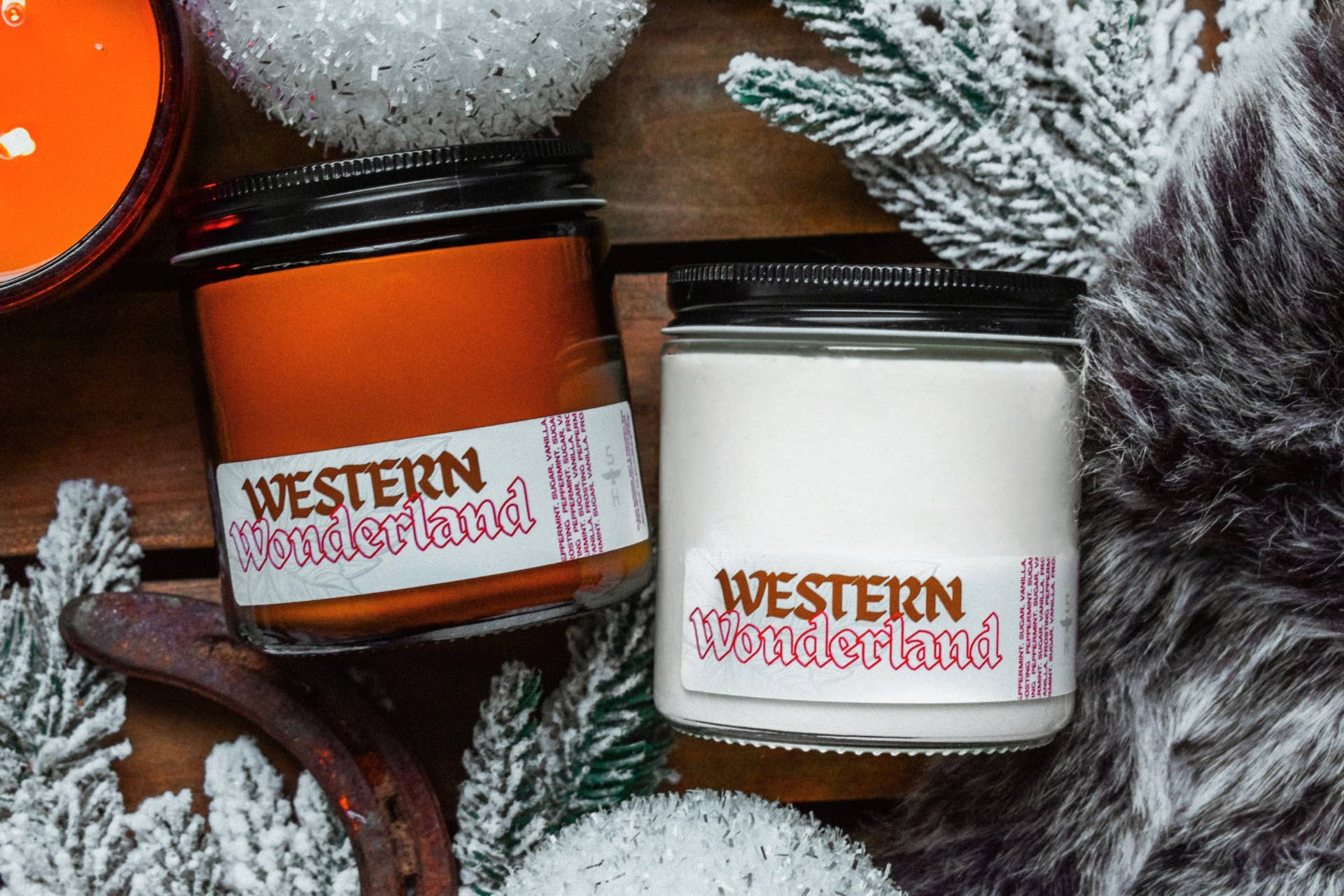 Two candles labeled 'Western Wonderland' on a wooden surface with decorative elements.
