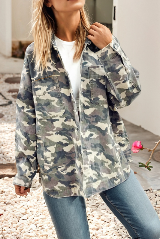 Person wearing a camouflage jacket and jeans outdoors.