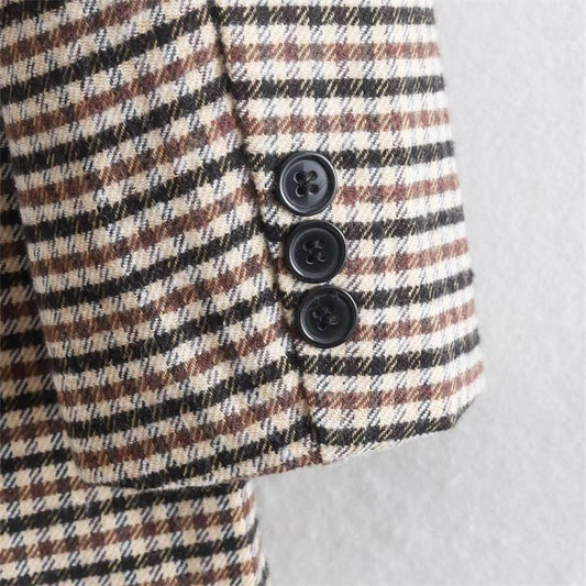Plaid jacket with black buttons on a light gray background
