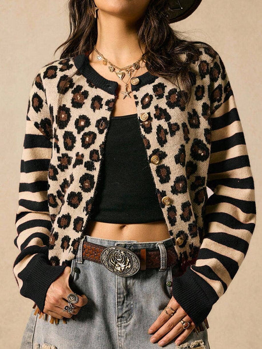 Model in a button cheetah cardigan with black/ tan striped sleeves. wearing a chunky gold necklace, baggy blue jeans with hand tooled belt and a silver belt buckle.