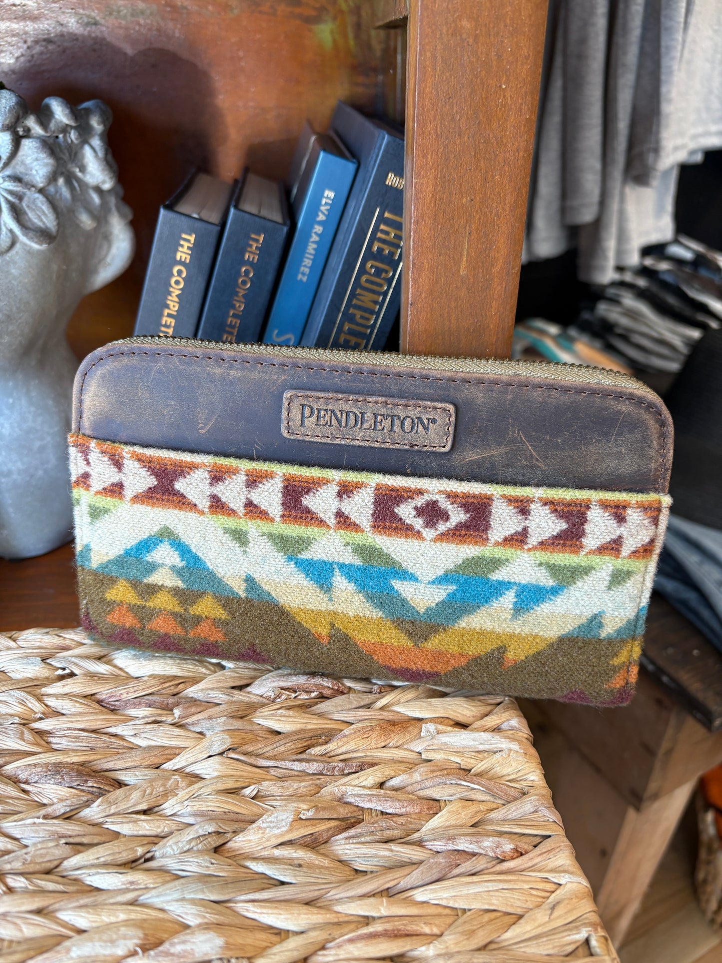 Pendleton patterned wallet on a stack of books with a woven surface in the background
