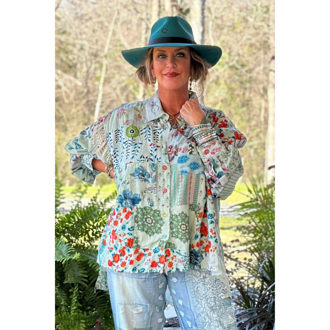 Woman wearing a colorful patterned shirt and teal hat outdoors