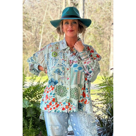 Woman wearing a colorful patterned shirt and teal hat outdoors