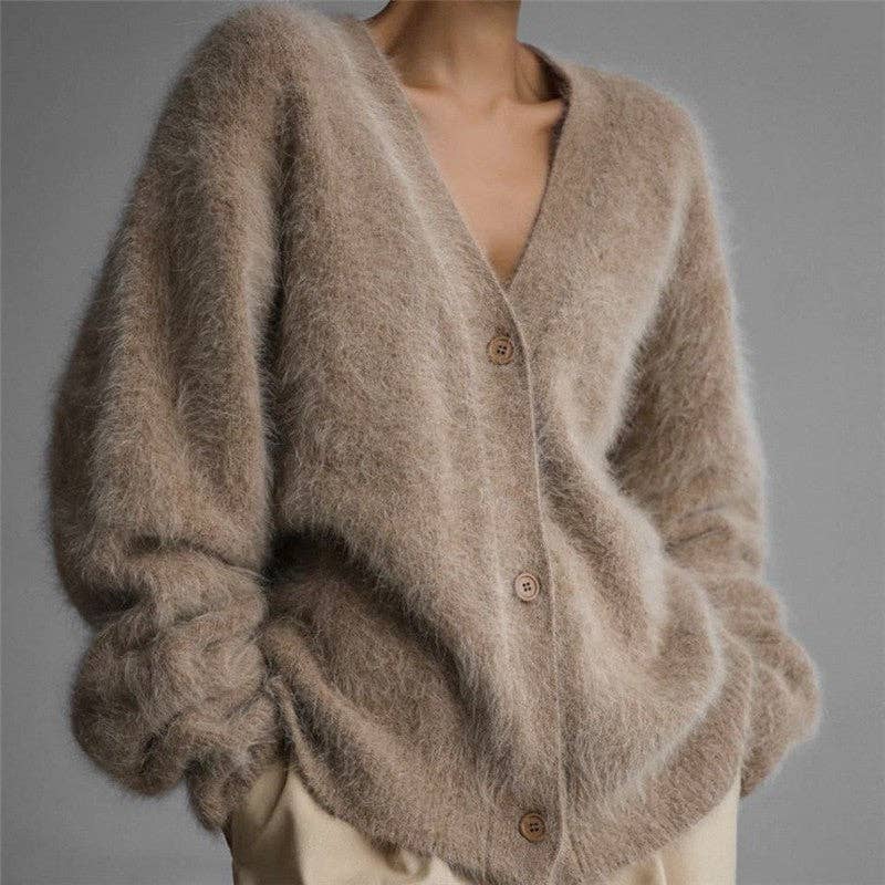 Brown fuzzy cardigan worn by a person on a gray background