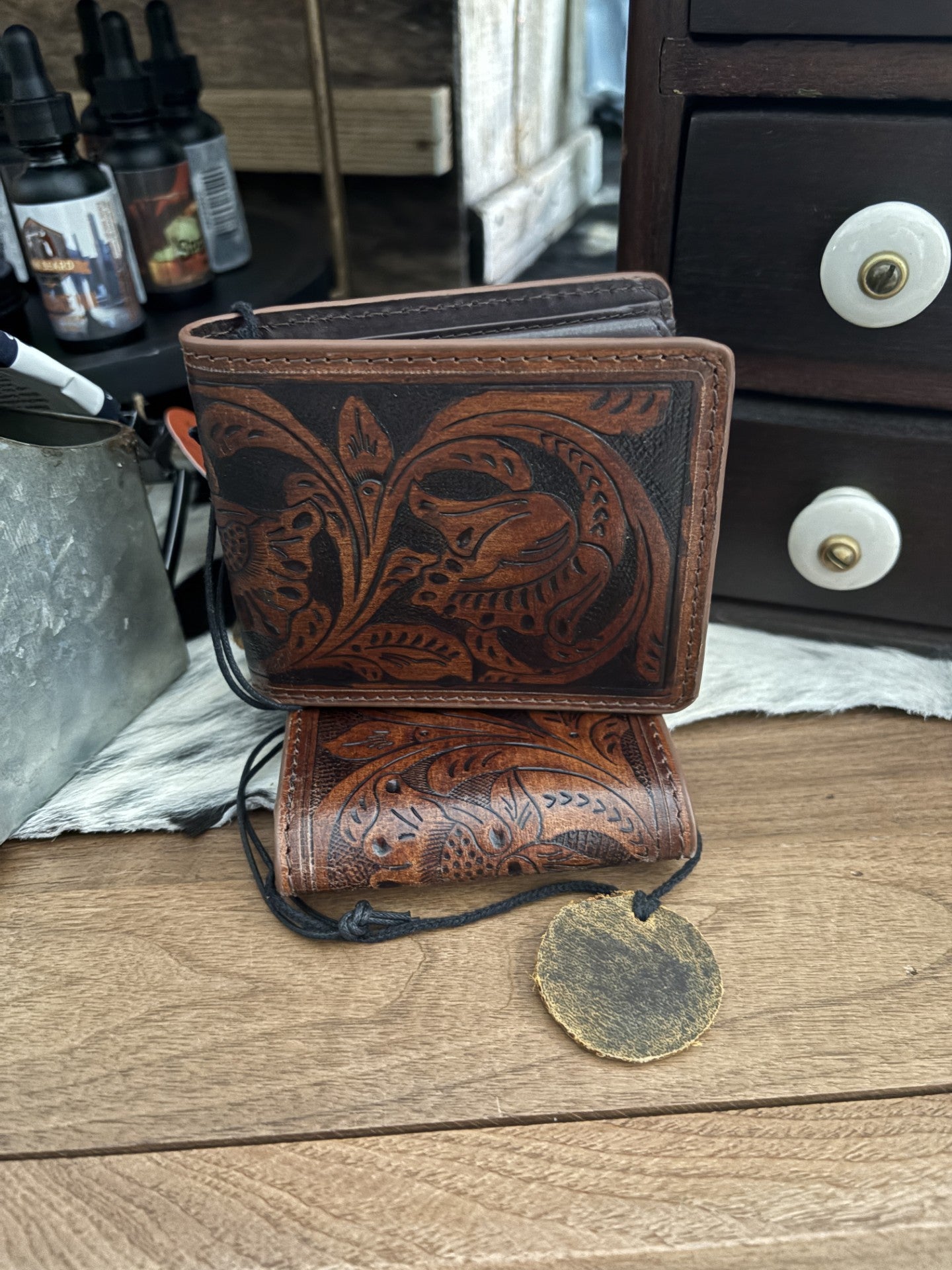 Brown leather wallet with intricate designs on a wooden surface