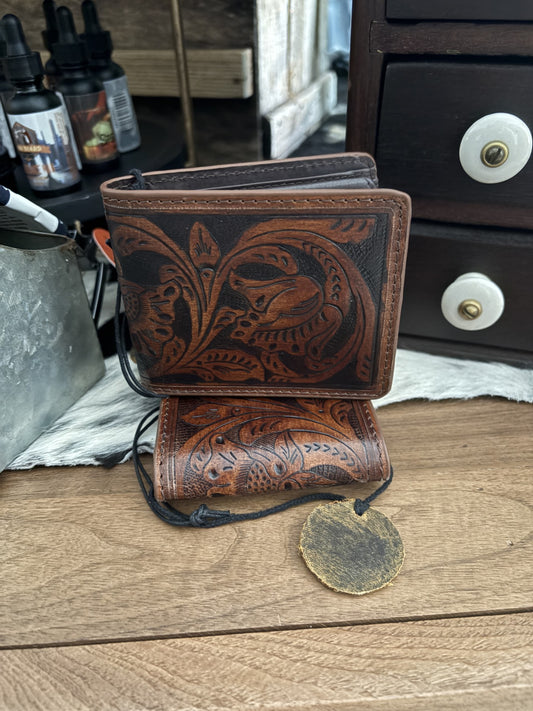 Brown leather wallet with intricate designs on a wooden surface